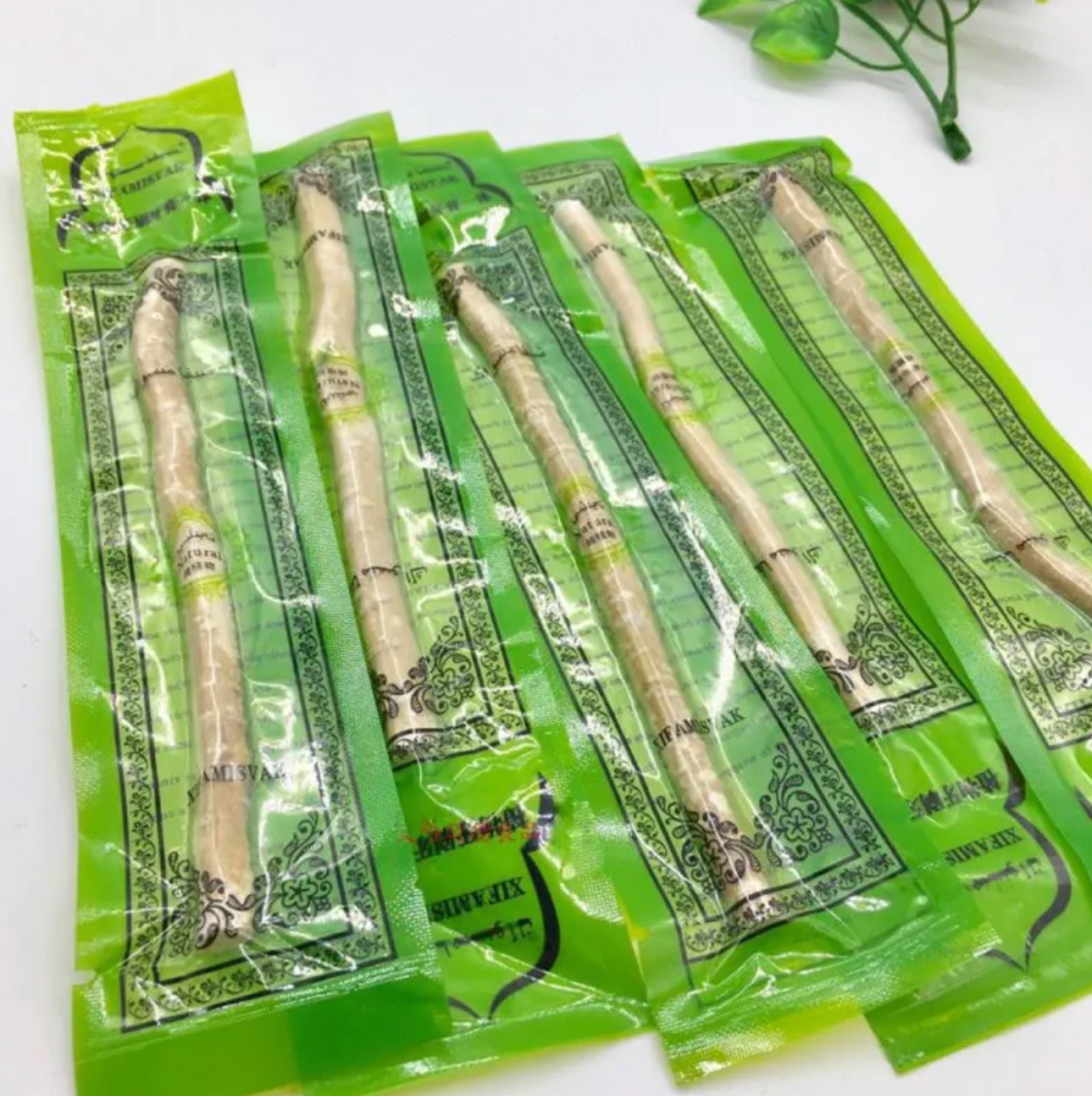 Several miswak tooth cleaning sticks in green vacuum packs