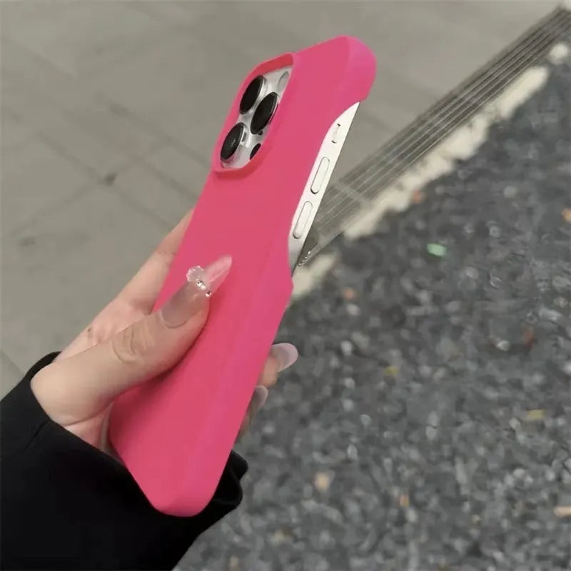 Hand holding a hot pink half-pack graphite phone case outdoors shown upright