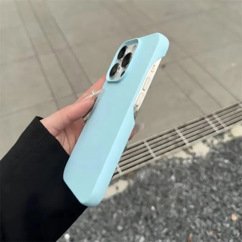 Hand holding a light blue half-pack graphite phone case outdoors on a white background