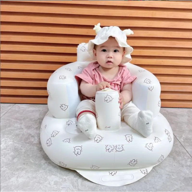 Baby girl in a pink outfit sitting in a white inflatable baby chair