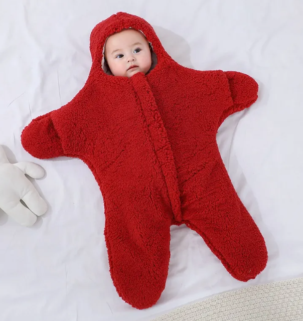 Baby in a red hooded fleece starfish-shaped baby quilt sleep sack, front view