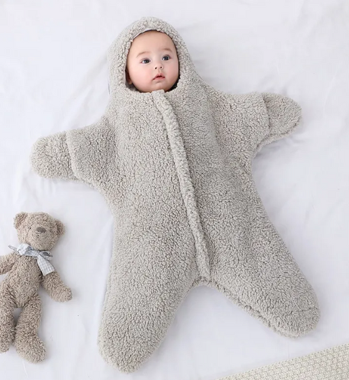 Baby in a gray hooded fleece starfish-shaped baby quilt sleep sack