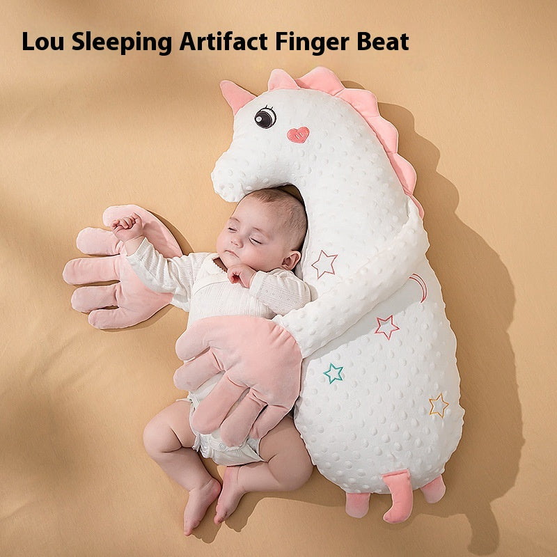 Baby sleeping beside a white unicorn soothing pillow with pink hands
