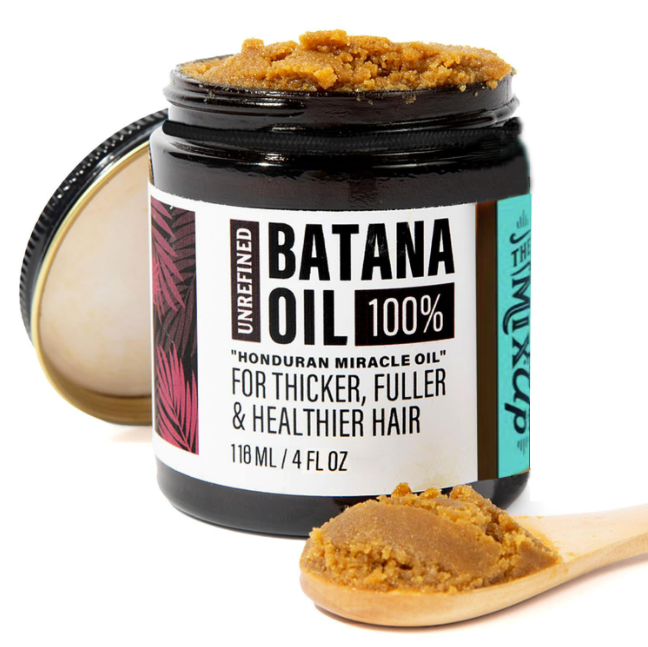Jar of 100% batana oil hair mask with a wooden scoop, front view
