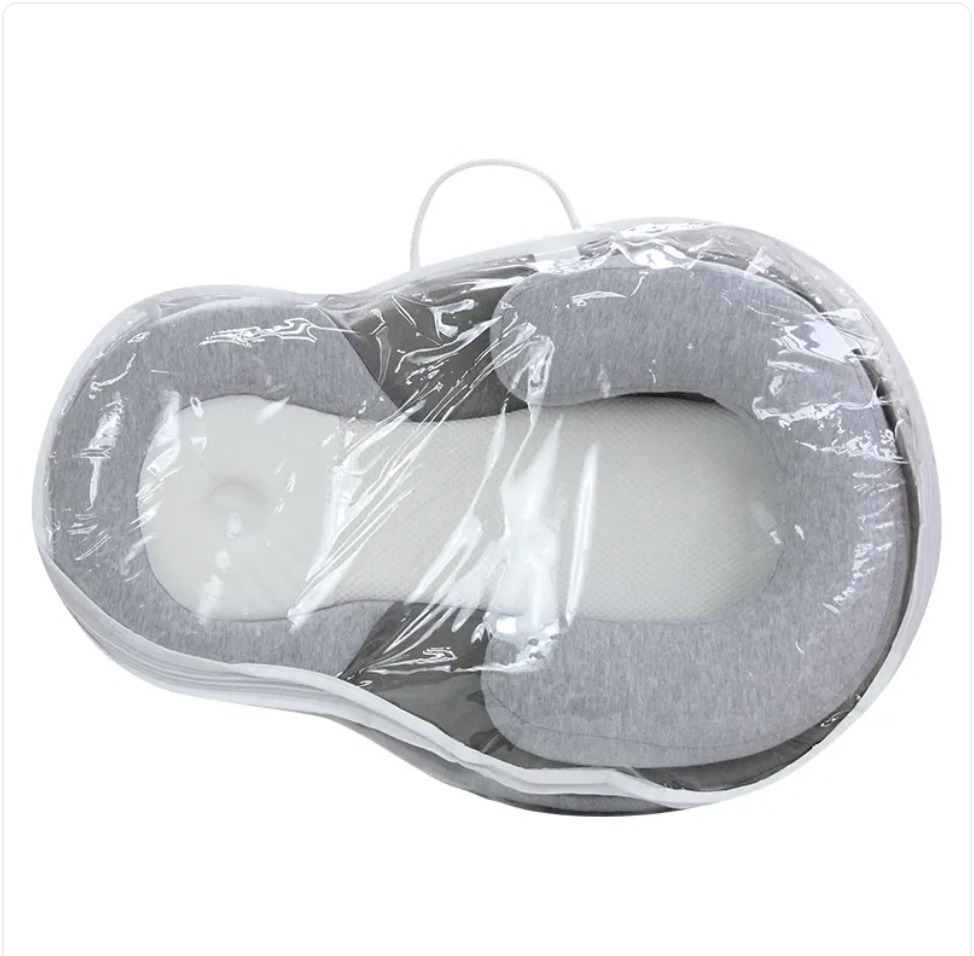 Gray anti-spit-up baby pillow in clear plastic packaging