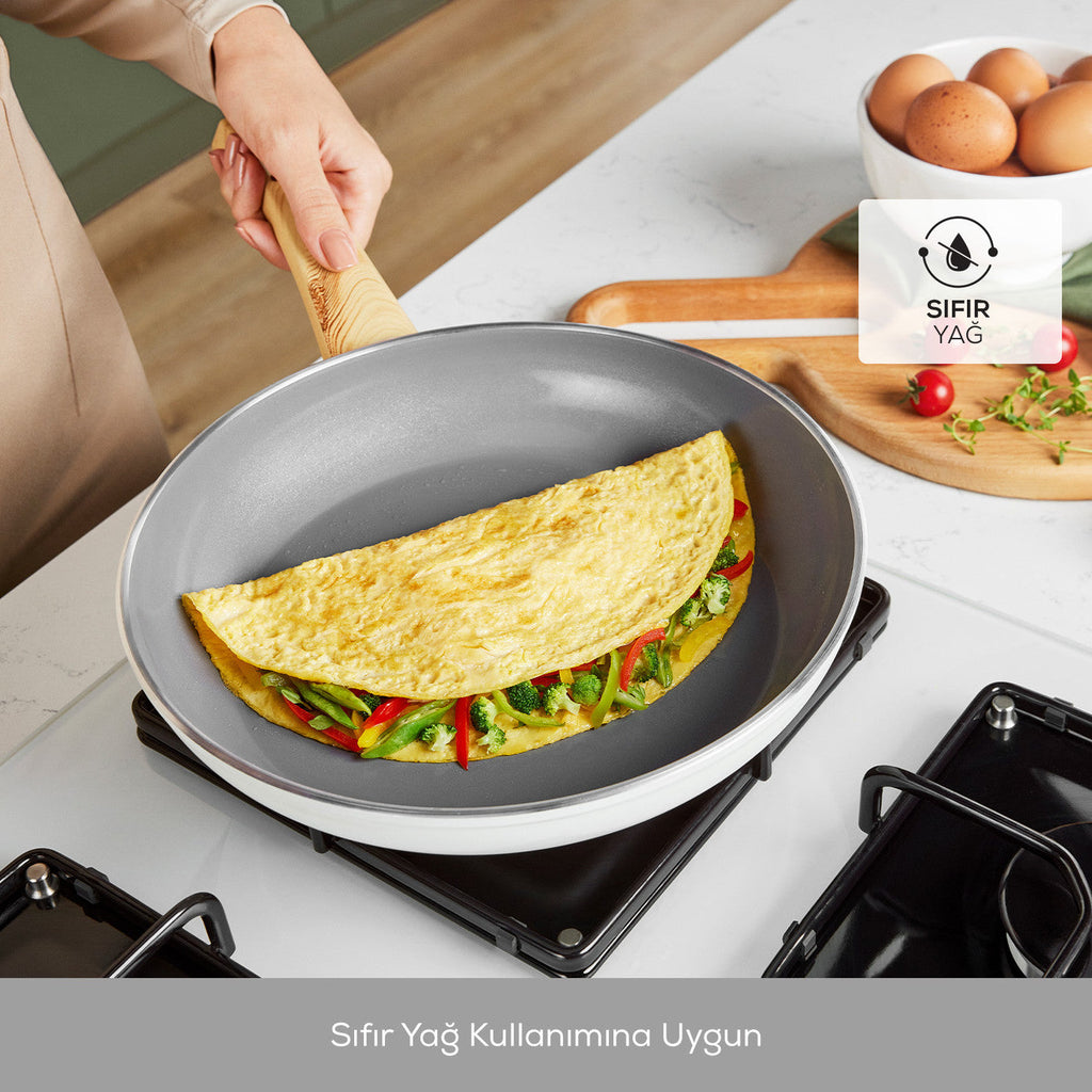 Omelet cooking in a nonstick frying pan on a gas stove