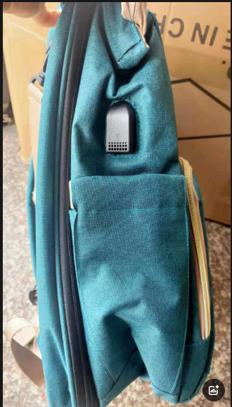 Side view of a teal mommy backpack showing its USB port