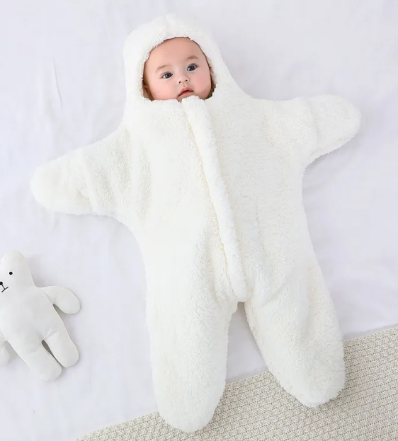 Baby in a white hooded fleece starfish-shaped baby quilt sleep sack