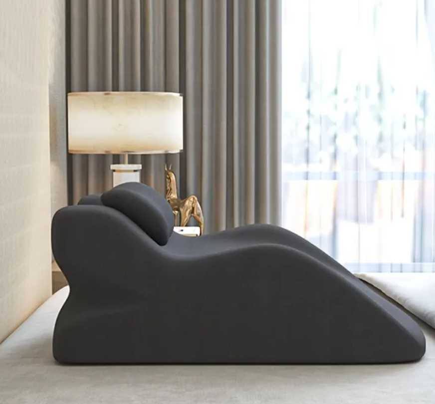Dark gray stomach sleeper pillow on a bed in a bedroom