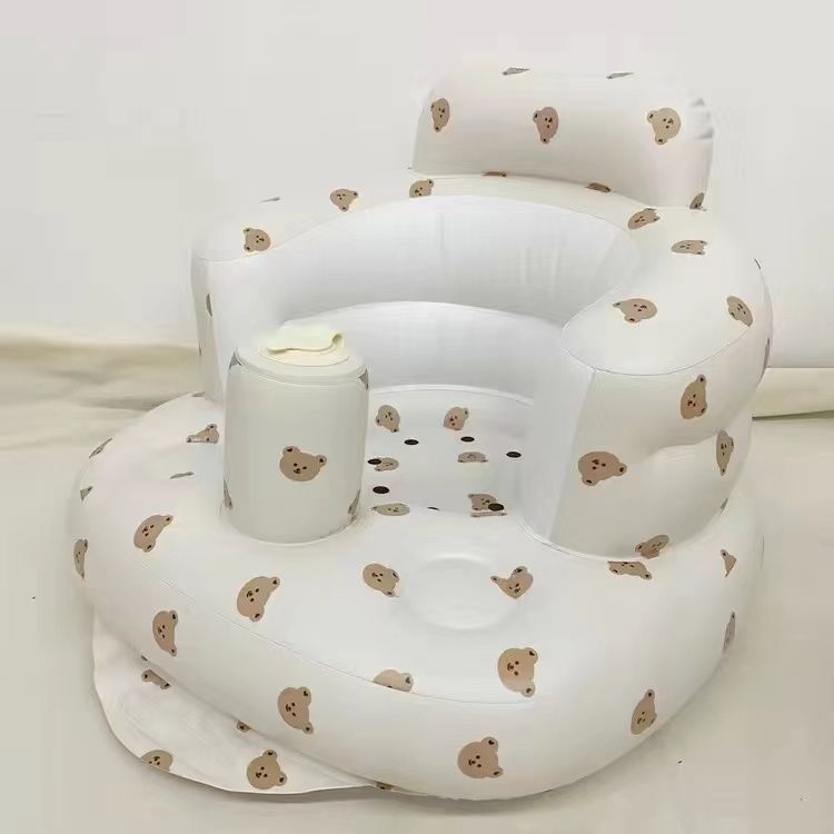 Bear print inflatable baby chair in a sunny room by a wicker basket, front view