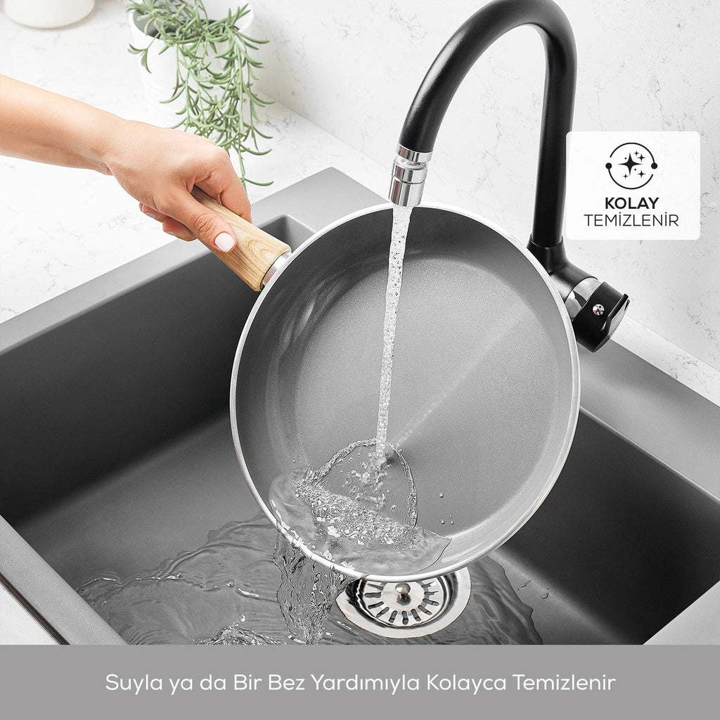 Nonstick frying pan rinsed clean under a kitchen faucet