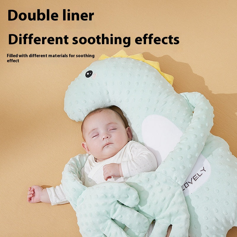 Close-up of a baby asleep in a mint dinosaur soothing pillow