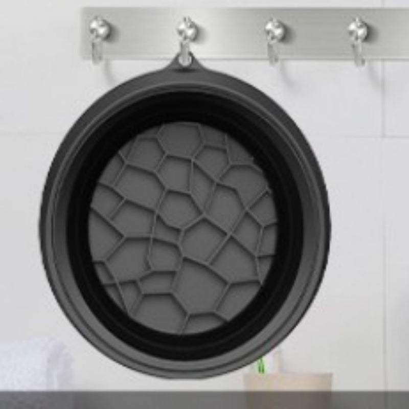 Black collapsible silicone ice basin hanging on a wall hook