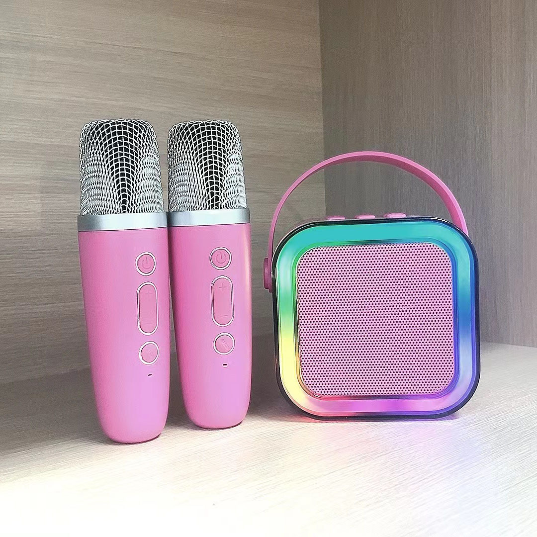 Bright pink Bluetooth karaoke speaker with two pink microphones