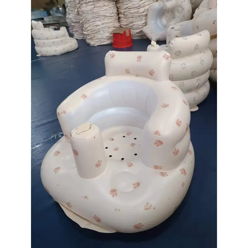 Inflatable baby chair with bear print, angled view on a navy floor, front view