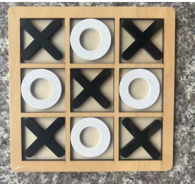Wooden tic-tac-toe board game with black X and white O pieces on granite, front view