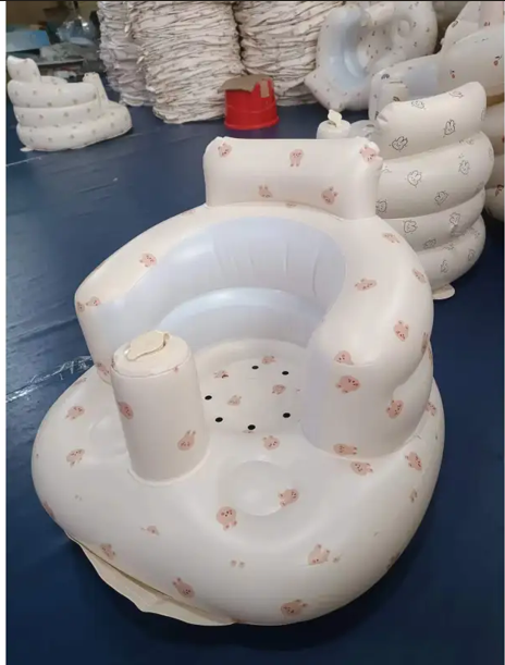 Inflatable baby chair with bear print, angled view on a navy floor