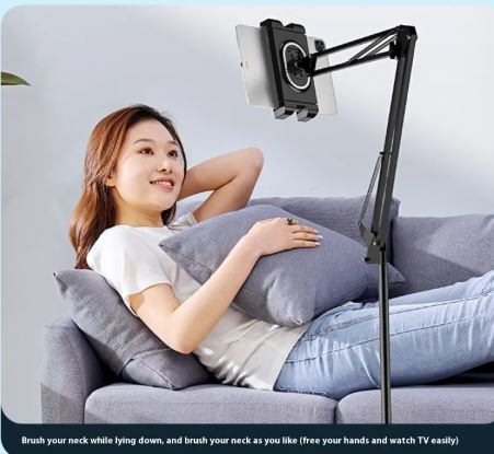 Woman on a couch scrolling a phone on a stand with a ring remote