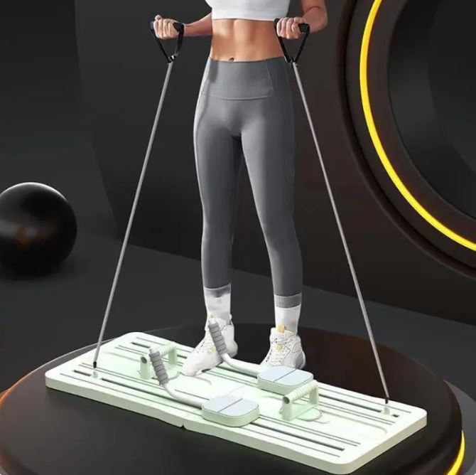 Woman standing on a white Pilates board pulling resistance cords