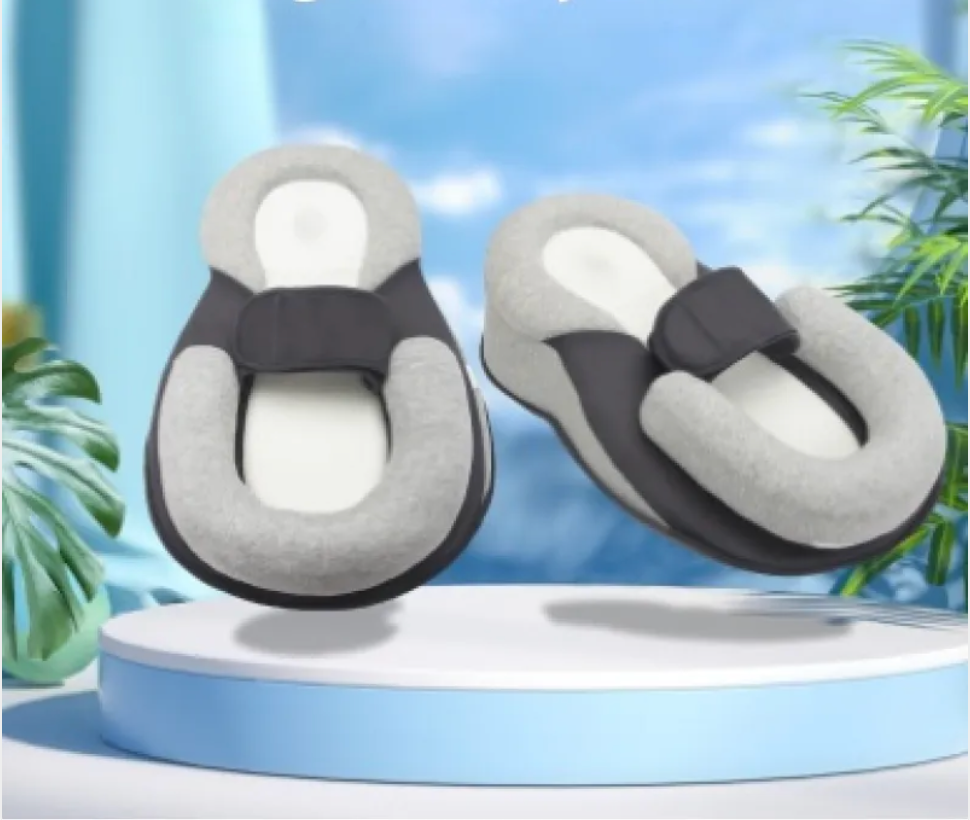 Two gray anti-spit-up baby pillows on a blue display stand, front view