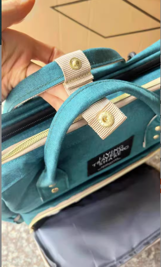 Close-up of the teal mommy bag's handle and zipper