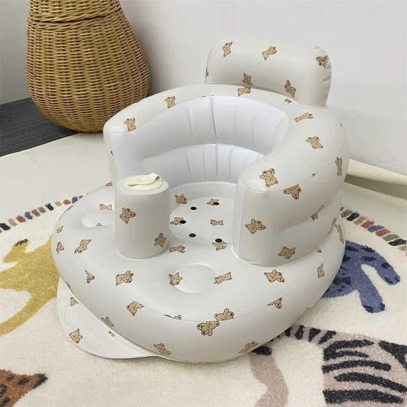 Bear print inflatable baby chair in a sunny room by a wicker basket shown upright