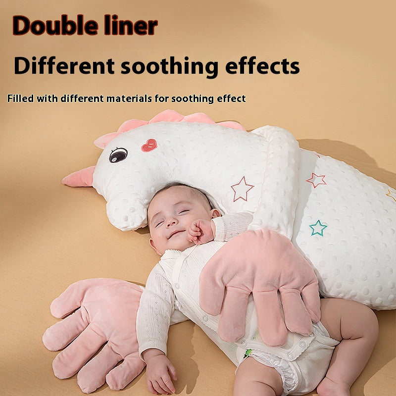 Baby resting under the arm of a white unicorn soothing pillow