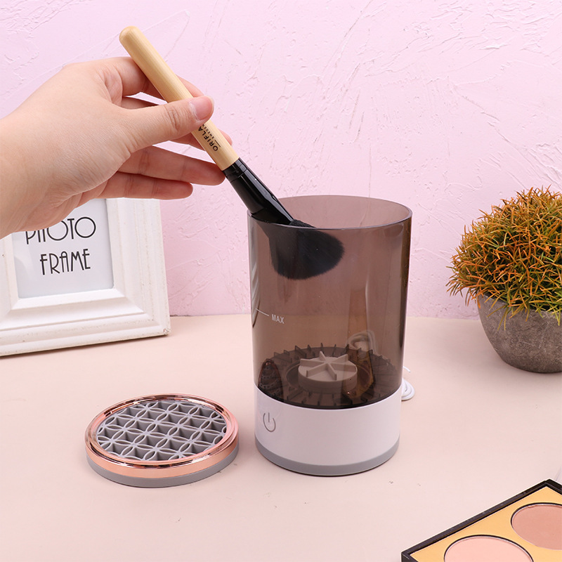 Hand placing a makeup brush in the brush cleaner