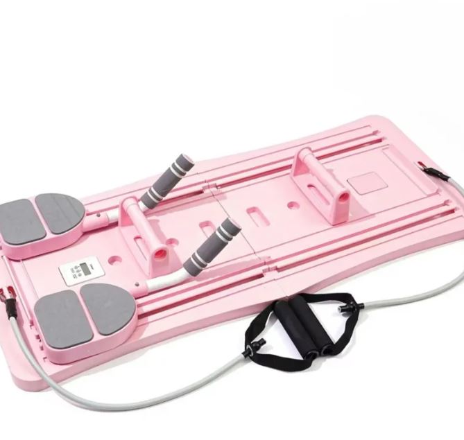Pink Pilates sliding board with foot pads and resistance bands, front view