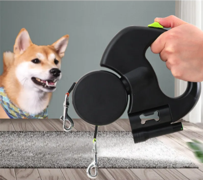 Hand holding a black double dog leash beside a smiling dog
